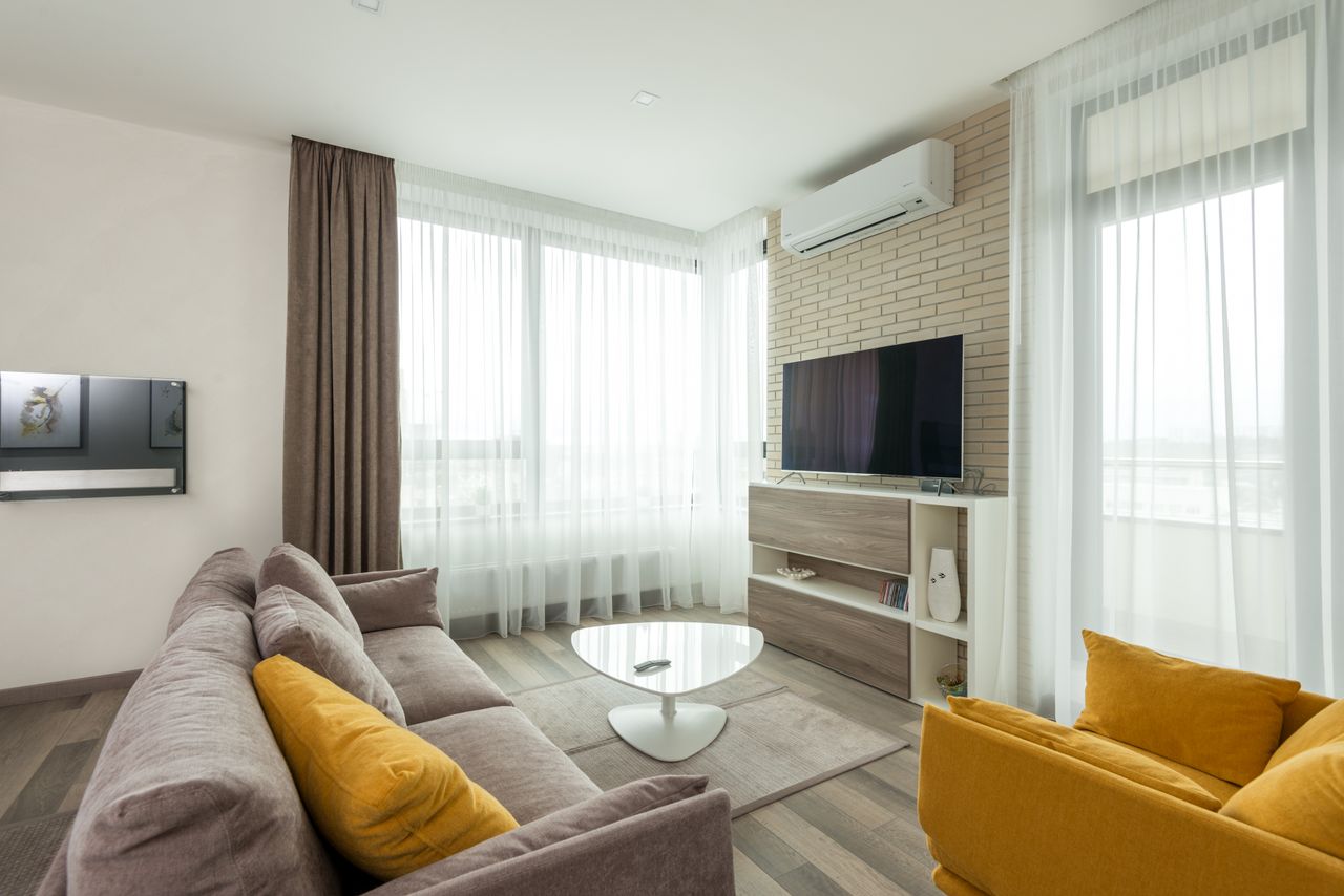 The Art of Drawing Readers In: Your attractive post title goes here Soft comfortable sofa with cushions and armchair placed in front of TV hanging on brick wall in spacious living room of modern apartment